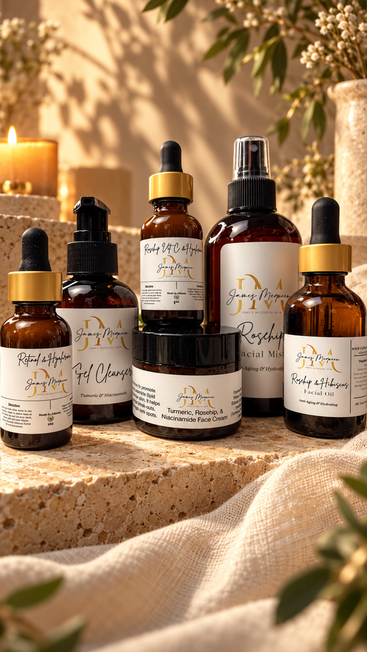 Six skincare bottles and jars from the brand James McQueen Skin arranged on a stone ledge with a linen cloth and candles in the background.